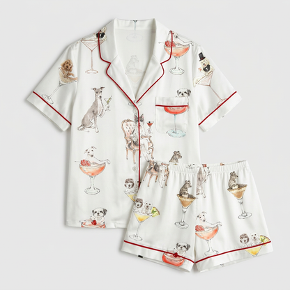 Women's satin pajama set with watercolor dogs in martini, coupe and spritz glasses on white - flat lay