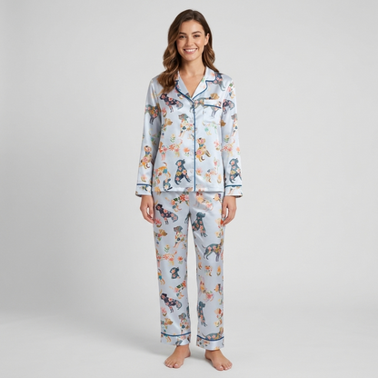 Women's satin pajama set with dog silhouettes filled with orange, pink and navy flowers on white with blue piping - long sleeve and pants