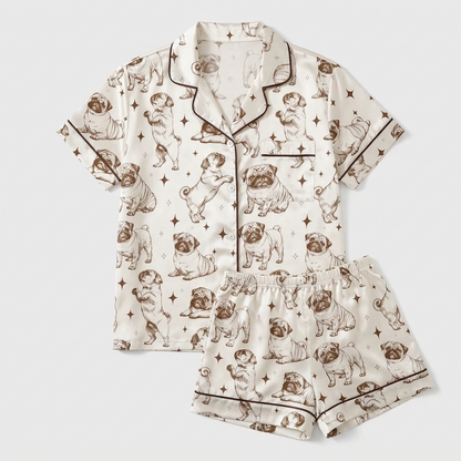 Women's satin pajama set with pencil-sketched pugs with tiny stars on ivory - flat lay