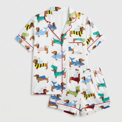 Women's satin pajama set with dachshunds dressed as sharks, dinosaurs, bees, unicorns and bunnies on white with red piping - flat lay