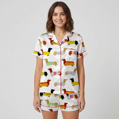 Women's satin pajama set with dachshunds in gingham and striped sweaters, one dressed as a hot dog, on white - short sleeve and shorts