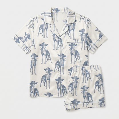 Women's satin pajama set with slate blue whippets in tiny cowboy hats on white with blue piping - flat lay
