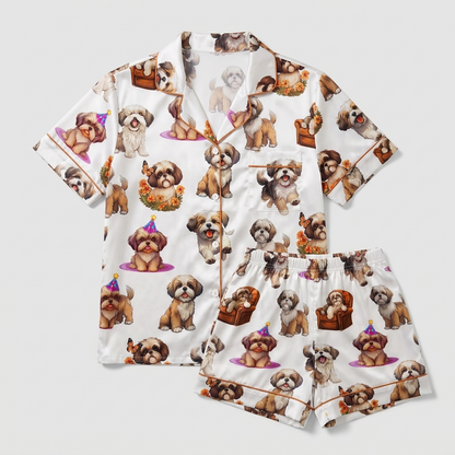 Women's satin pajama set with brown-and-white shih tzus in party hats, armchairs and autumn wreaths on white - flat lay