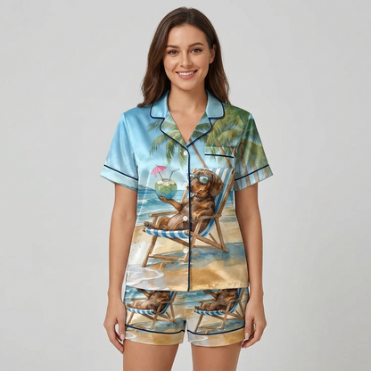 Women's satin pajama set in light blue with a dachshund in sunglasses in a striped beach chair under palms - short sleeve and shorts