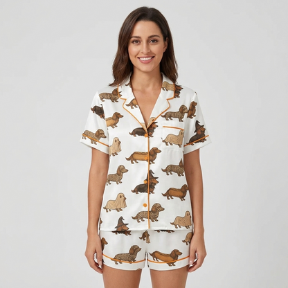 Women's satin pajama set with dachshunds dressed as ghosts, mummies and witches on creamy white with orange piping - short sleeve and shorts