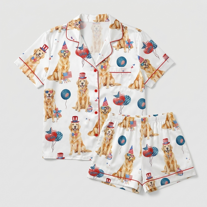 Women's satin pajama set with golden retrievers in star top hats and heart sunglasses among flags and balloons - flat lay