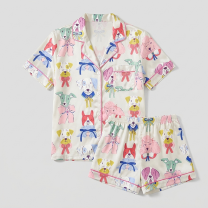 Women's satin pajama set with pastel pup faces tied in satin ribbons on white - flat lay