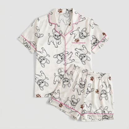 Women's satin pajama set with black line-drawn French bulldogs on white with hot pink piping - flat lay