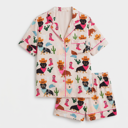 Women's long-sleeve satin pajama set with dachshunds in cowboy hats and boots among cacti on blush peach - flat lay