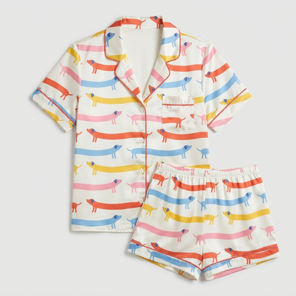 Women's satin pajama set with dachshunds in coral, yellow, sky blue and pink stripes on creamy white with pink piping - flat lay