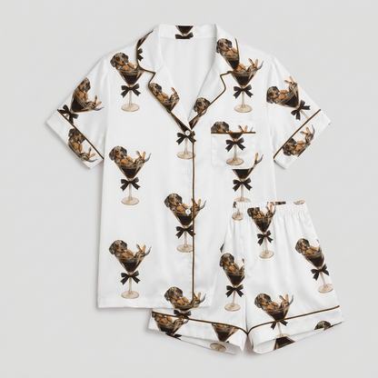 Women's satin pajama set with dachshunds lounging in martini glasses on white - flat lay