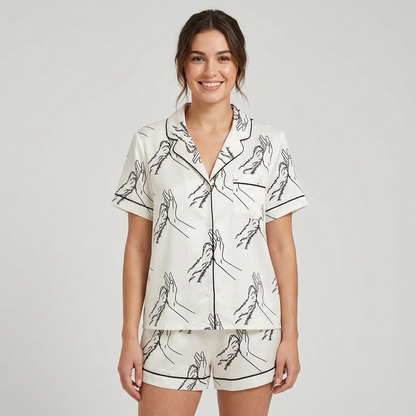 Women's satin pajama set with line-art hand and dog paw high fives on white - short sleeve and shorts