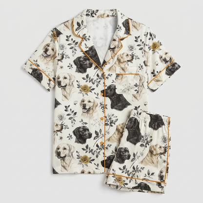 Women's satin pajama set with black and golden Labradors among leaves and wildflowers on white - flat lay