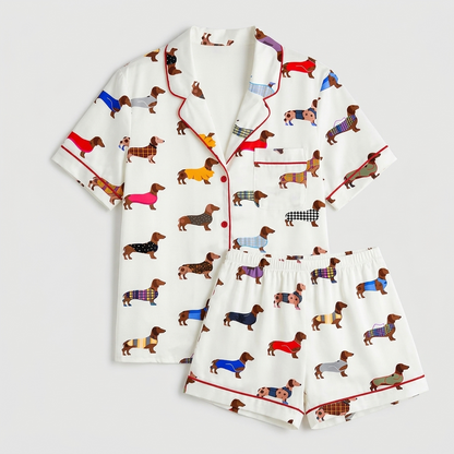 Women's satin pajama set with dachshunds in plaid, check and tartan coats on white with red piping - flat lay