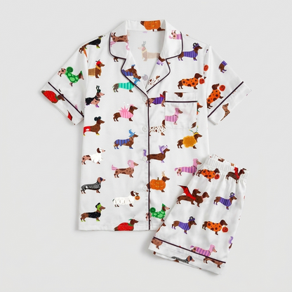 Women's satin pajama set with dachshunds in orange, teal, purple and red coats and costumes on white - flat lay