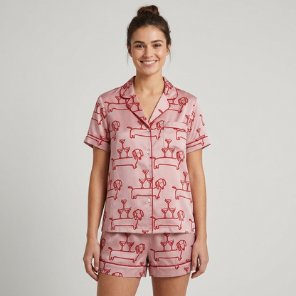 Women's long-sleeve satin pajama set with dachshunds and cocktail glasses in red line art on blush pink - short sleeve and shorts