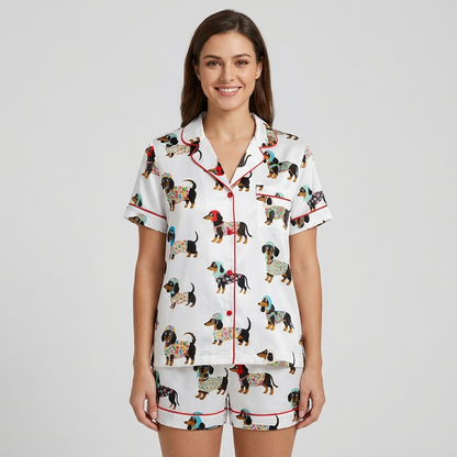 Women's satin pajama set with black-and-tan dachshunds in patterned sweaters and knit hats on white with red piping - short sleeve and shorts