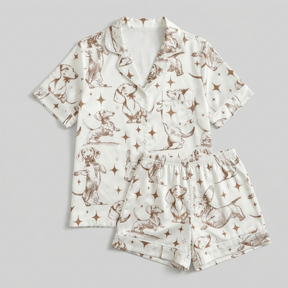 Women's long-sleeve satin pajama set with dachshunds among stars and crescent moons in brown line art on white - flat lay