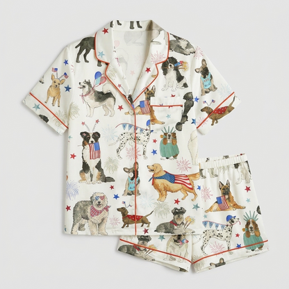Women's satin pajama set with dogs in flag bandanas and crowns among stars and fireworks on white - flat lay