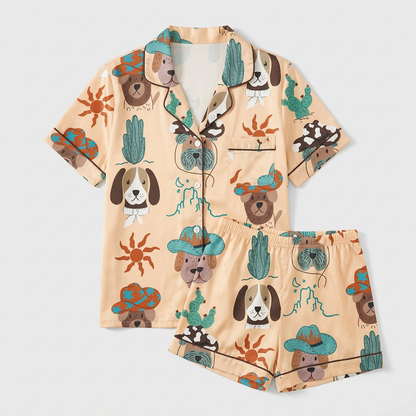 Women's satin pajama set in sand with floppy-eared pups in teal cowboy hats beside cacti and suns - flat lay