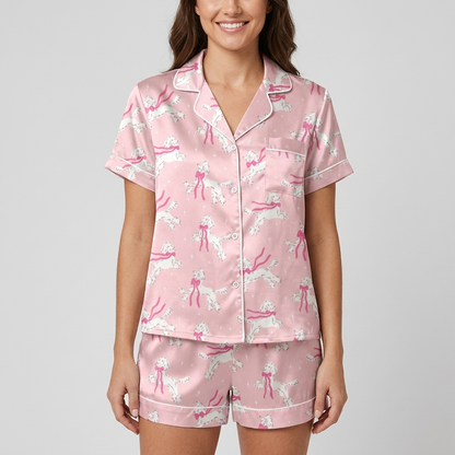 Women's satin pajama set with white poodles trailing hot pink ribbons on soft pink - short sleeve and shorts