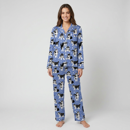 Women's satin pajama set with black-and-white huskies in scarves among snowflakes on periwinkle blue - long sleeve and pants