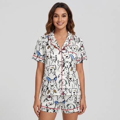 Women's satin pajama set with black line-drawn dogs and dalmatians with blue and mustard ears on white - short sleeve and shorts