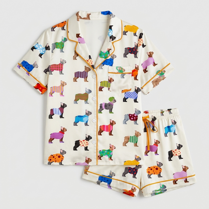 Women's satin pajama set with French bulldogs in striped, polka dot and plaid sweaters on white - flat lay