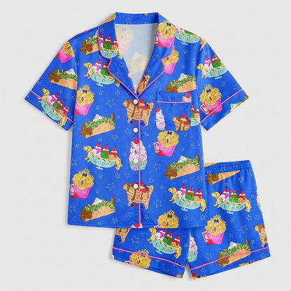 Women's satin pajama set with golden retrievers nestled in burgers, tacos, fries and sundaes on bright blue - flat lay