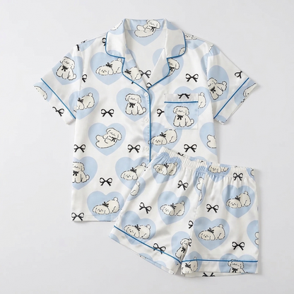 Women's satin pajama set with sleepy white fluffy dogs in sky-blue hearts on white - flat lay