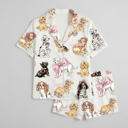 Women's satin pajama set with cavalier spaniels, goldens and a Scottie in big pink bows on white - flat lay