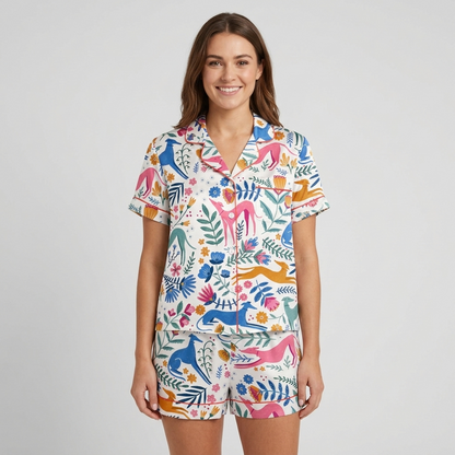 Women's satin pajama set with colorful whippets leaping through a folk-art garden of tulips on white - short sleeve and shorts
