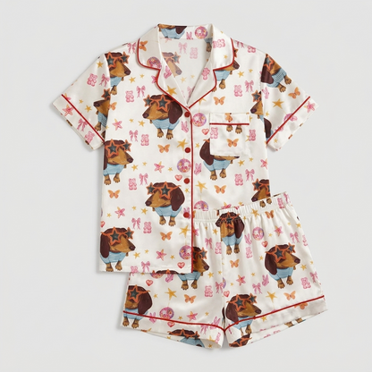 Women's satin pajama set with dachshunds in star sunglasses, pink bows and butterflies on white with red piping - flat lay