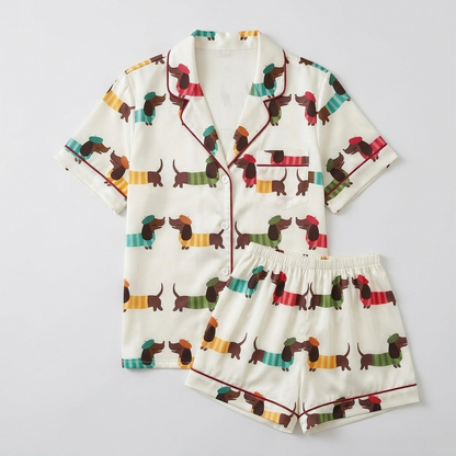 Women's satin pajama set with dachshunds in mustard, teal, green and red striped sweaters on white - flat lay