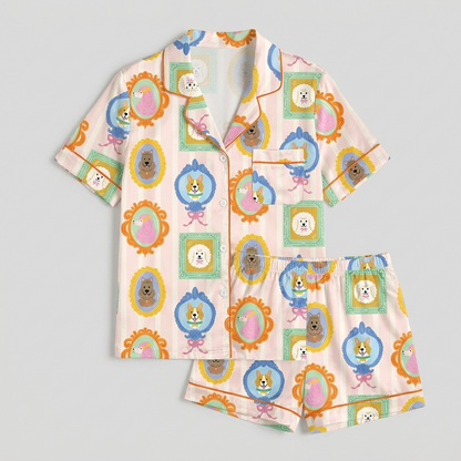 Women's satin pajama set with corgis and poodles in ornate frames on candy-striped blush pink - flat lay