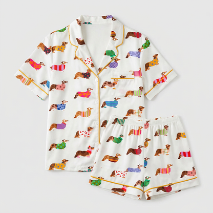 Women's satin pajama set with corgis in polka dot, striped and heart-print sweaters on white - flat lay