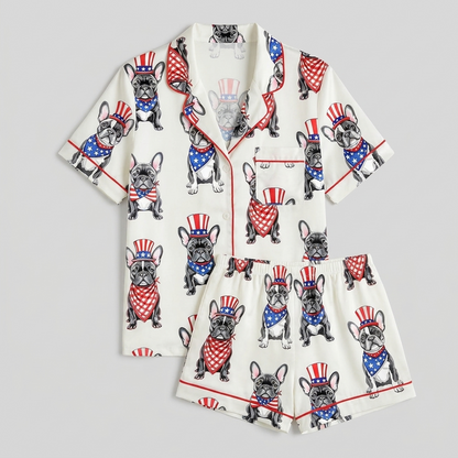 Women's satin pajama set with black French bulldogs in red, white and blue top hats and star bandanas on white - flat lay
