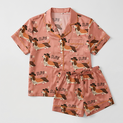 Women's satin pajama set with long-eared hound dogs in black cowboy hats with stars on salmon pink - flat lay