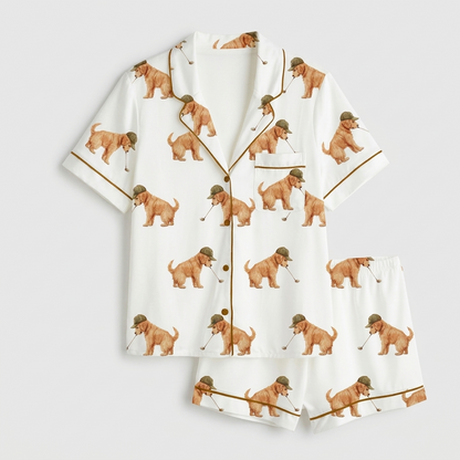 Women's satin pajama set with golden retriever puppies in tweed flat caps swinging golf clubs on white - flat lay