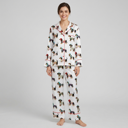 Women's satin pajama set with black-and-tan dachshunds in patterned sweaters and knit hats on white with red piping - long sleeve and pants