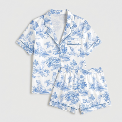 Women's satin pajama set with golden retrievers in a blue toile of trees and hills on white - flat lay