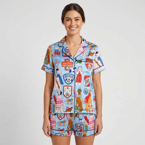 Women's satin pajama set in light blue with dogs in knit sweaters and shades among ski badges and gear - short sleeve and shorts
