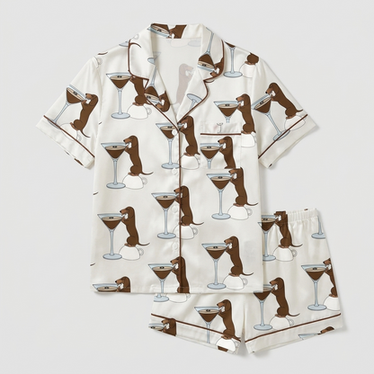Women's satin pajama set with basset hounds leaning into espresso martini glasses on white - flat lay