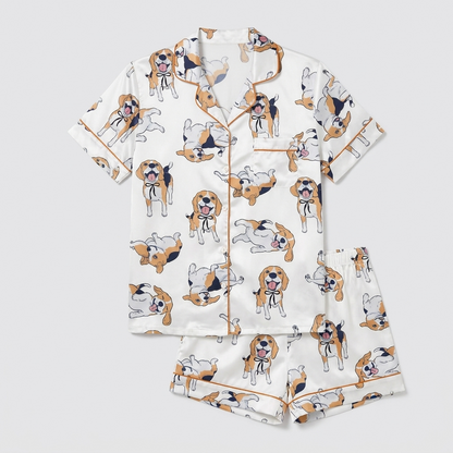Women's satin pajama set with tricolor beagles in black ribbon collars rolling over on white with copper piping - flat lay